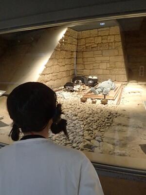 石室の復原展示を見る古代人。