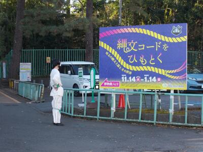 特別展看板前に立つ古代人