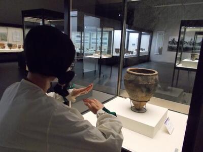 装飾のついた深鉢を観察する古代人。