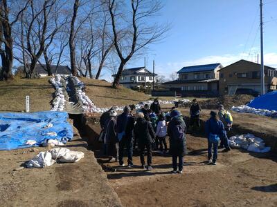 愛宕山古墳の発掘現場で学芸員が説明を行っているところ。