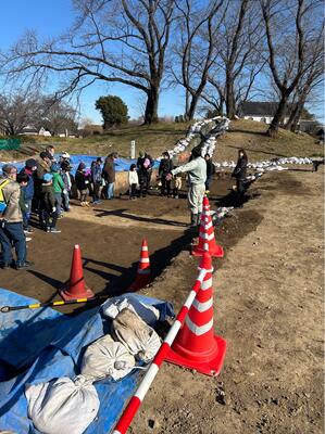 愛宕山古墳の発掘現場で学芸員が説明を行っているところ。